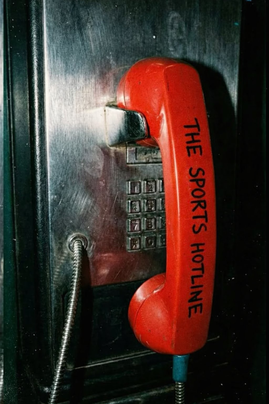 Red payphone labeled THE SPORTS HOTLINE